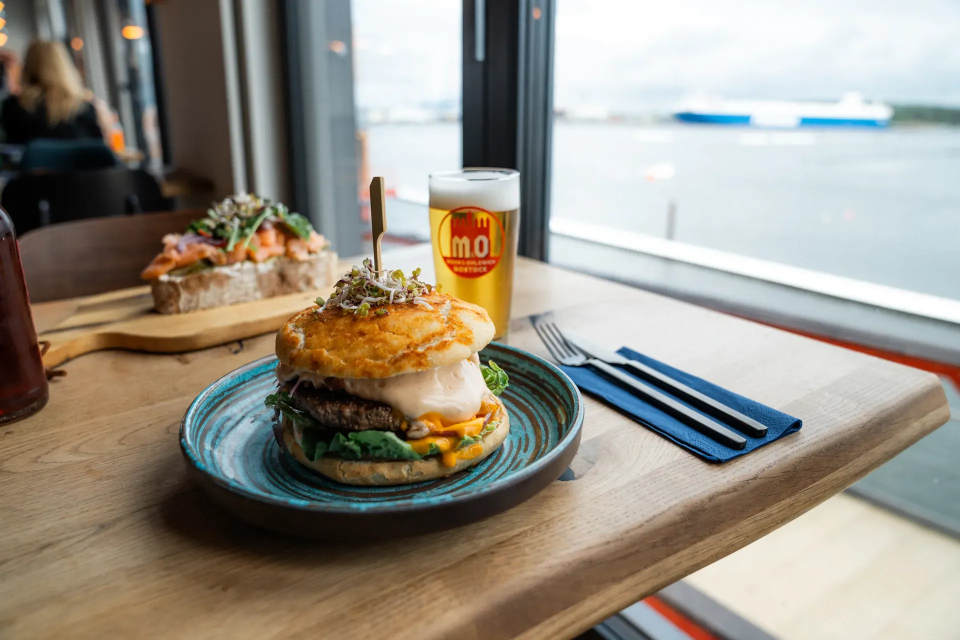 Burger und Bier im brise mit Blick auf das Wasser
