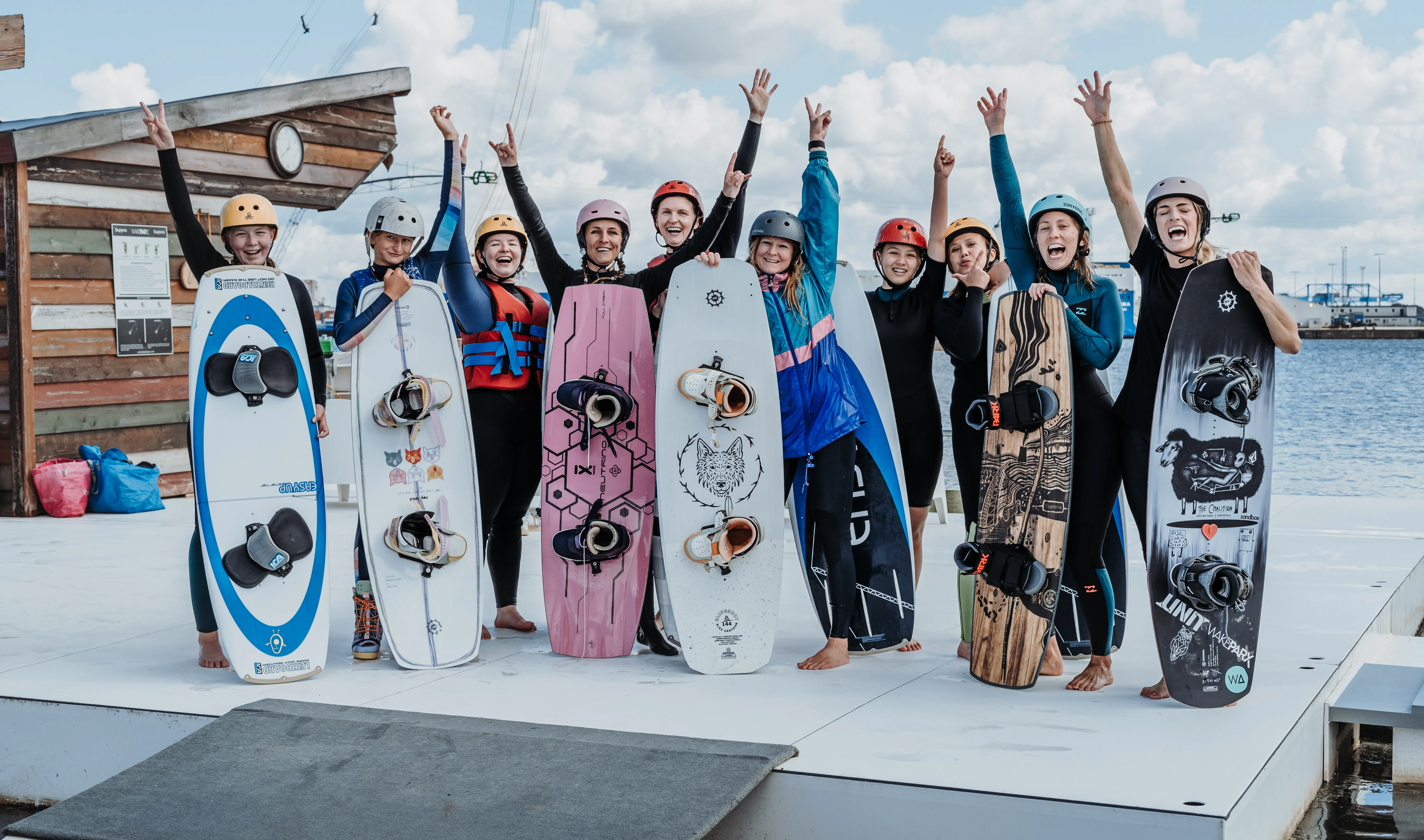 Frauen stehen gemeinsam mit Wakeboards bei einer Womens Wake Session
