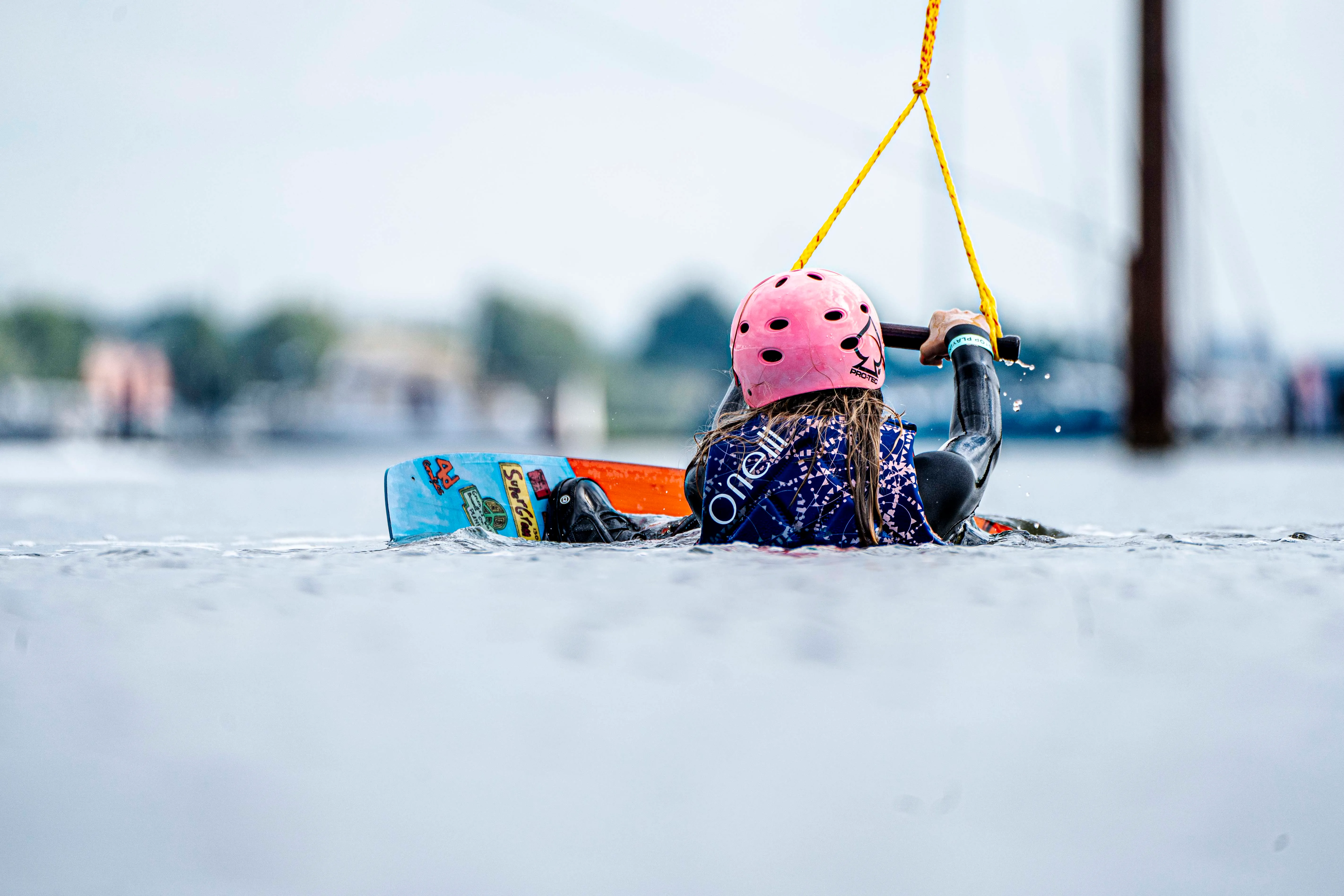 Kind startet beim Schnupperkurs an der 2.0 Anlage mit Wakeboard im Wasser
